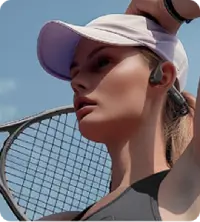 A woman playing tennis wearing Walla Sound Beat bone conduction headphones